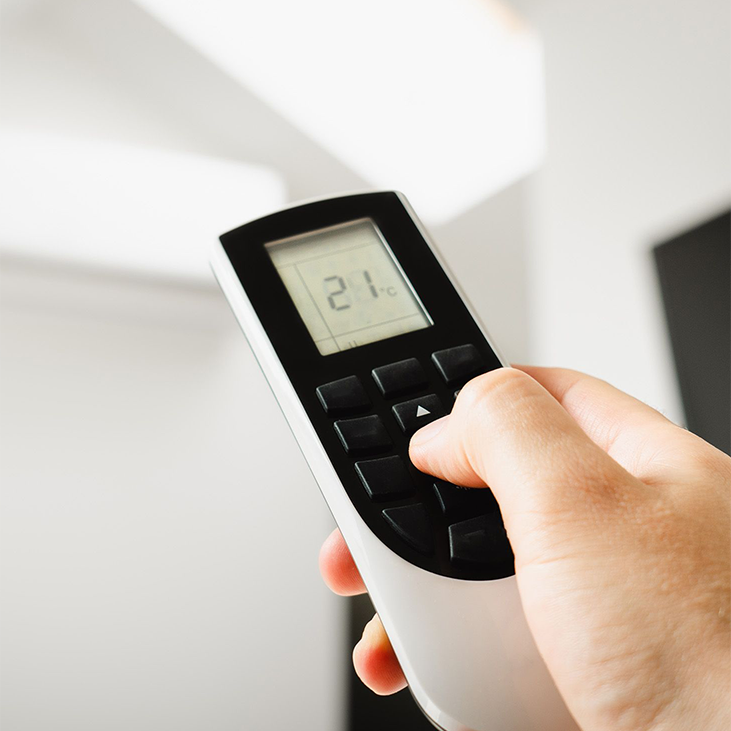 Air Conditioning remote in use with hands